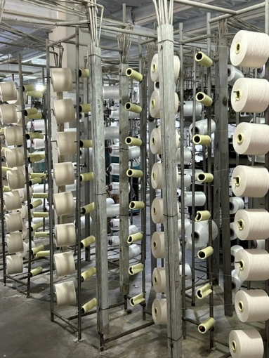Rekken met garenklossen bij een textielproductielocatie